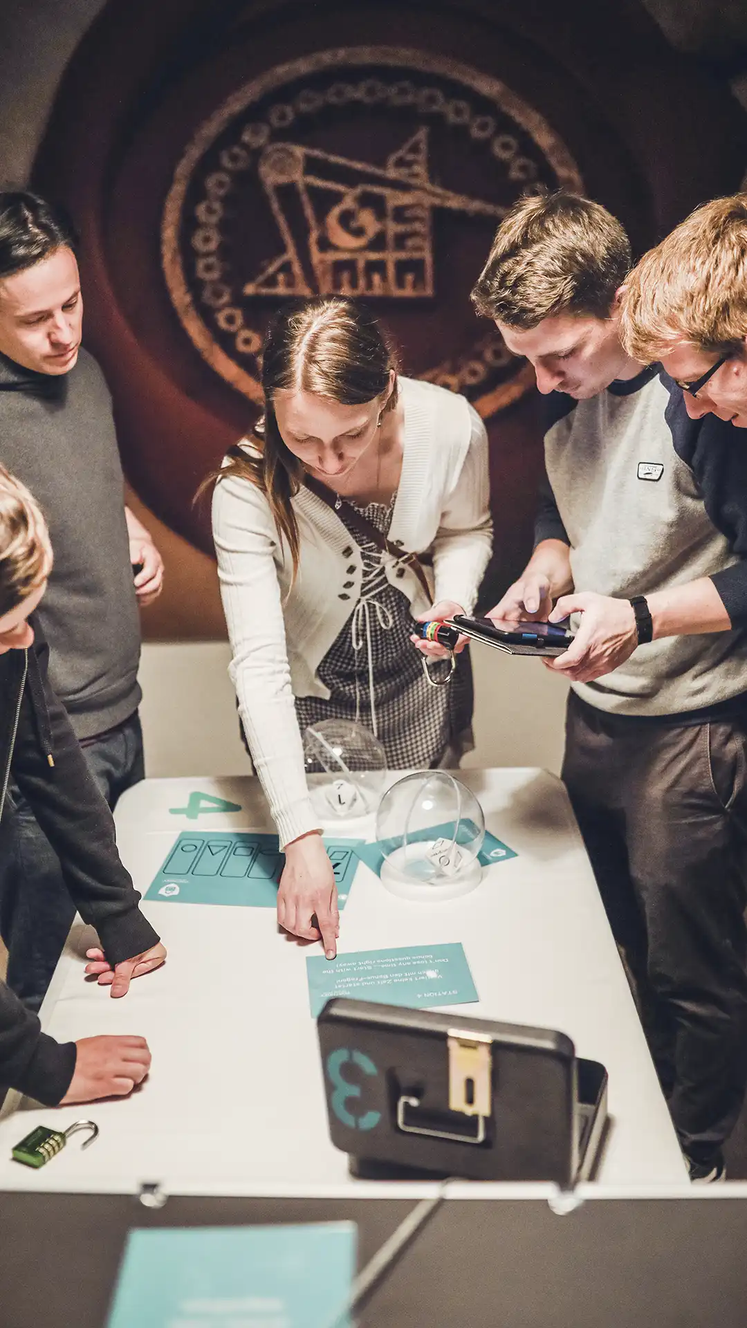 Escape Room+ für JGA und Geburtstag Freundinnen und Freunde knobeln lachend an einem Spieltisch