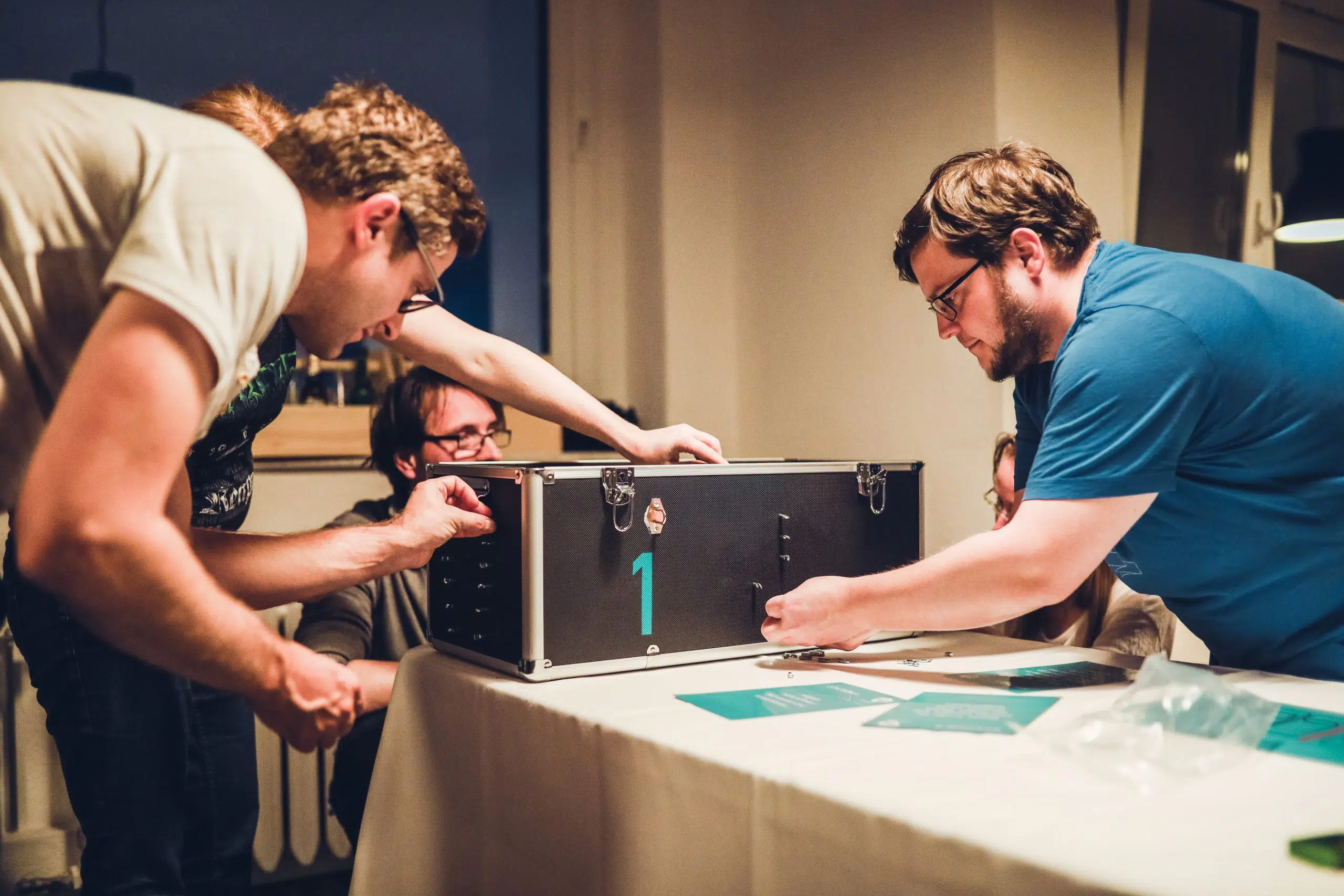 Escape Room+ bei euch vor Ort Team öffnet einen verschlossenen Koffer an einer Spielstation