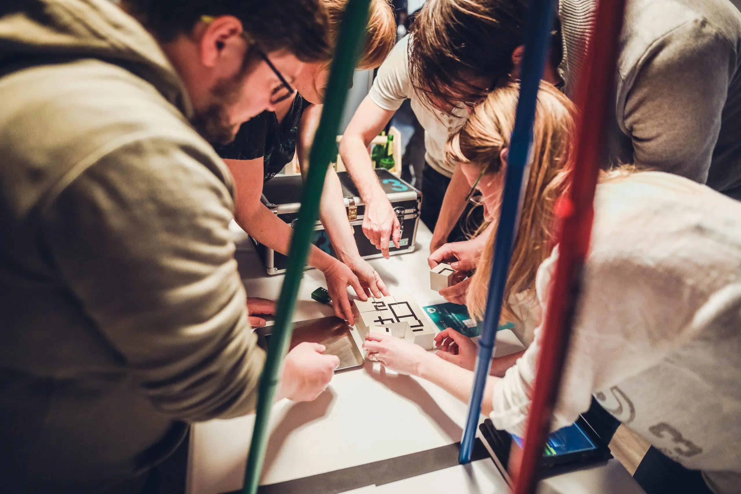 Escape Room+ für Schulklassen Jugendliche lösen gemeinsam ein Rätsel an einem Spieltisch